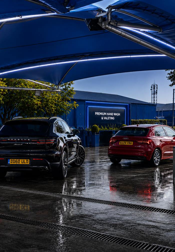 A Porsche and an Audi under the blue canopy at Springwood Hand Car Wash