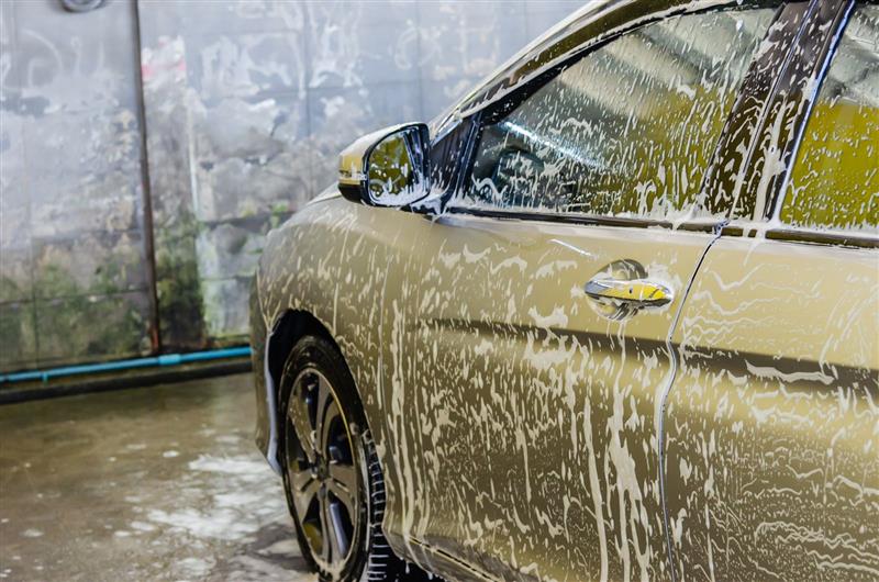 A car covered in snow foam during a hand wash